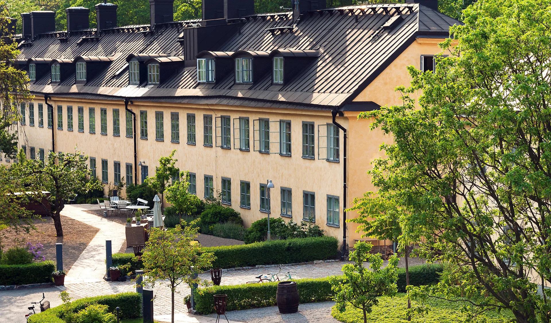 Long low former naval building with a courtyard, seen from the island path