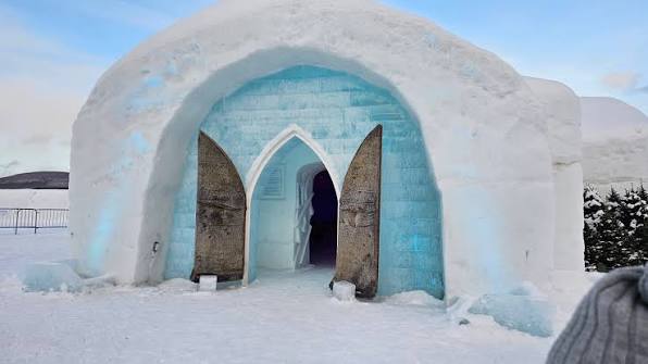 Vaulted corridor of packed snow with carved openings along both sides
