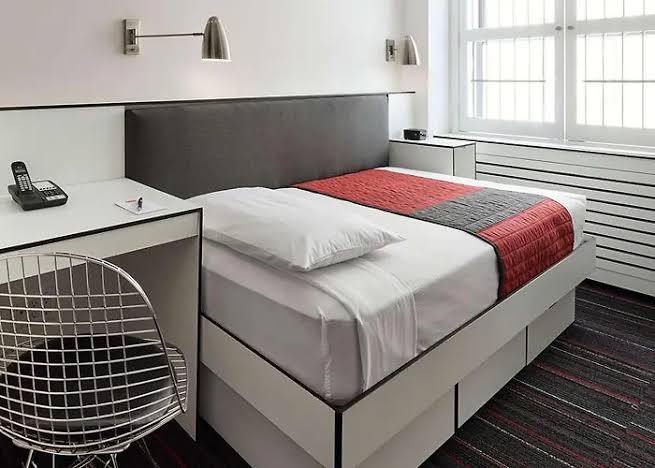 Compact hotel room with a built-in bed and storage beneath it
