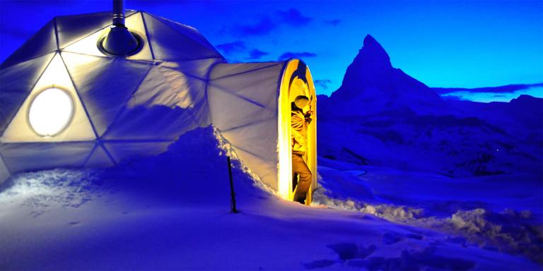 Cluster of snow domes on an open mountain terrace under a clear sky